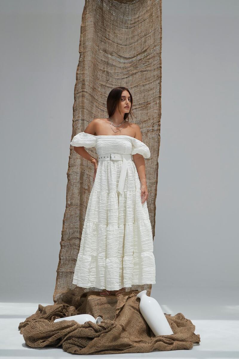 The Madiyah Al Sharqi x Karen Wazen spring / summer 2021 collaboration offers a belted bandeau dress in fresh white.  Courtesy Madiyah Al Sharqi