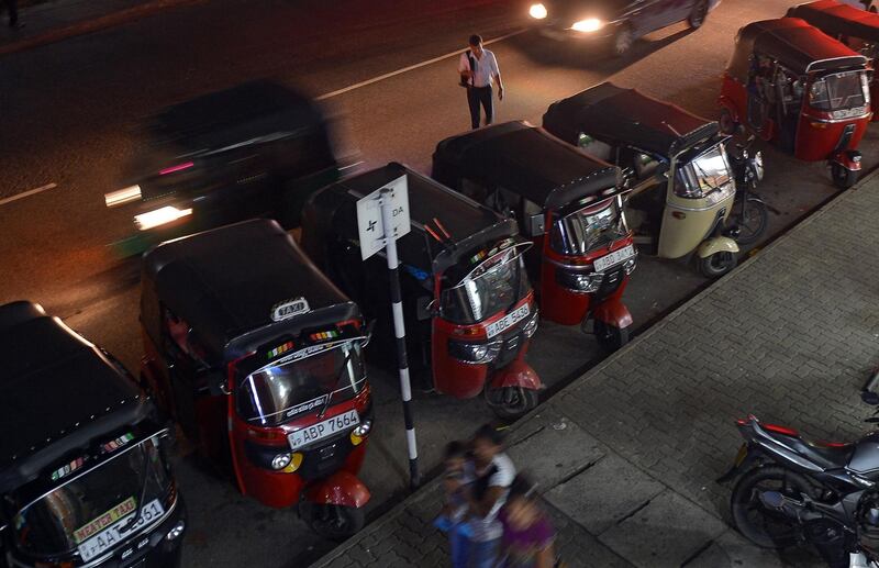 Sri Lankan three-wheeled taxi drivers wait for passengers along a road in Colombo on August 22, 2018. (Photo by LAKRUWAN WANNIARACHCHI / AFP)