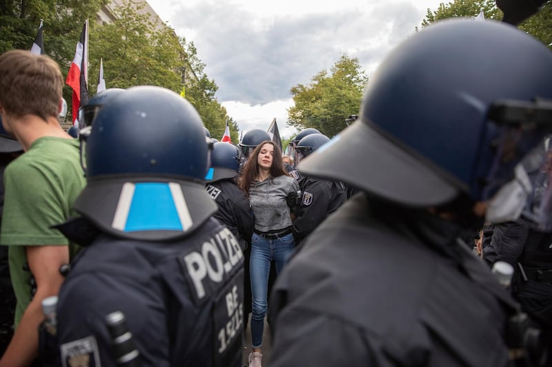 The police detain a woman during a demonstration against Covid-19 measures, in Berlin, Germany. dpa via AP