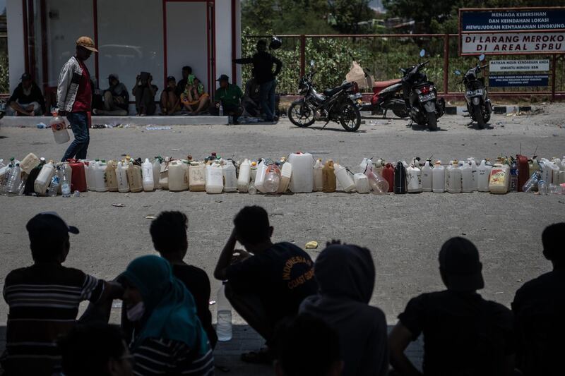 Makeshift jerry cans are lined up in order as people queue for fuel in Palu. Getty Images