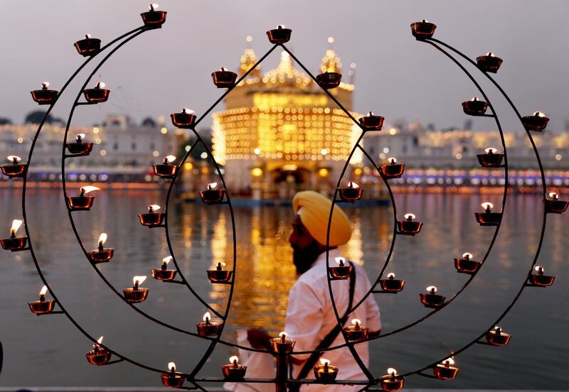 Lamps are lit by devotees as specially illuminated Golden Temple, the holiest of Sikh's religious sites is seen in the backdrop on the occasion of the 485th birth anniversary of the fourth Guru or the master of the Sikhs Sri Guru Ramdas Ji in Amritsar, India.  EPA