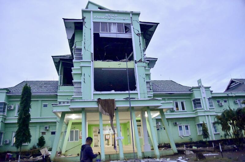 A man walks by a damaged hospital in Mamuju city after a 6.2-magnitude earthquake rocked Indonesia's Sulawesi island. AFP