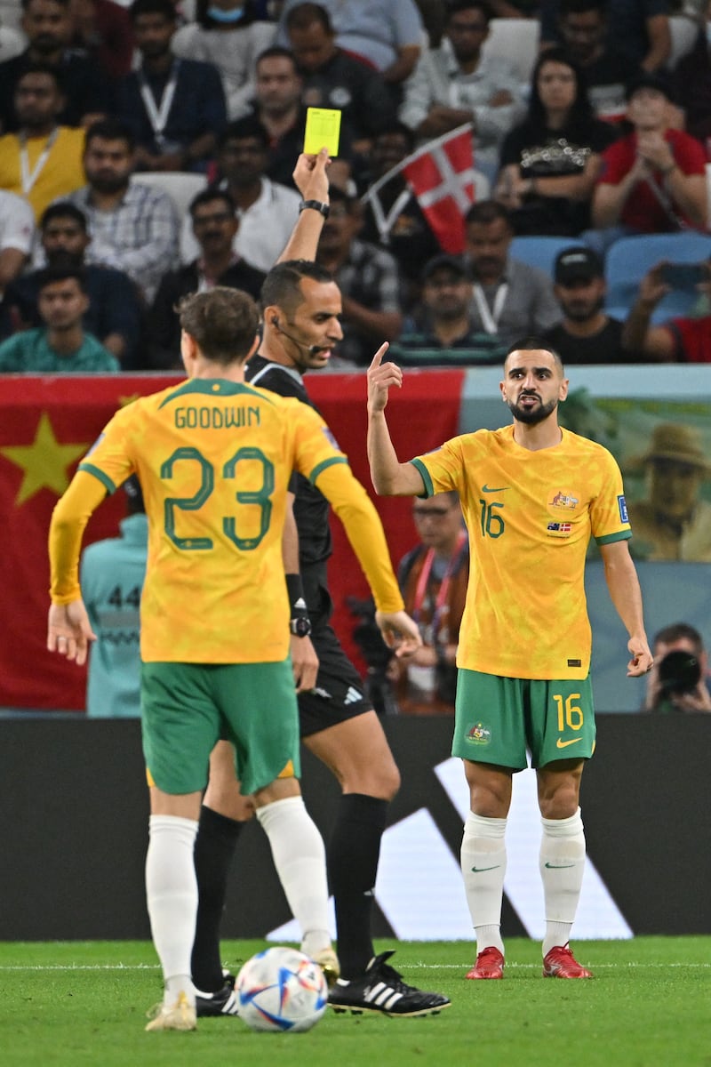 Referee Mustapha Ghorbal shows a yellow card to Australia's Aziz Behich in the first half. AFP