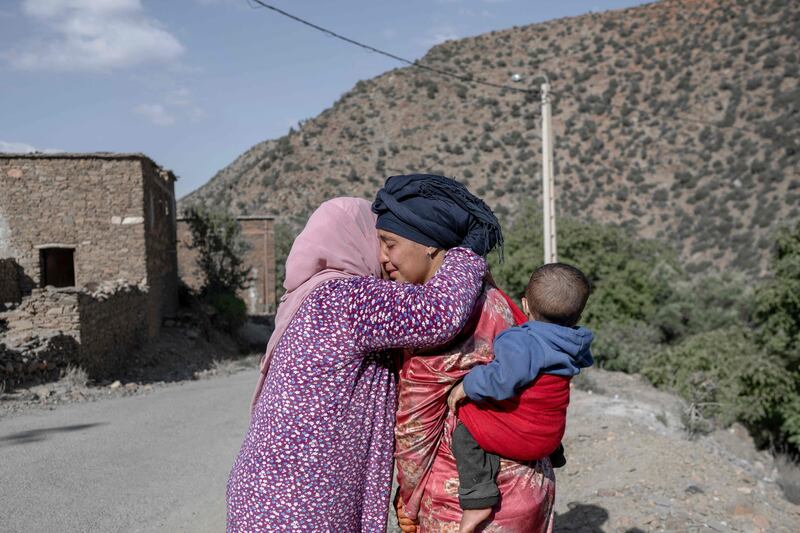 Earthquake survivors embrace each other. AFP