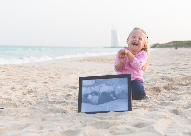 Little Cara holds a photo of herself after being born at 26 weeks. Courtesy JewelSeddon Photography