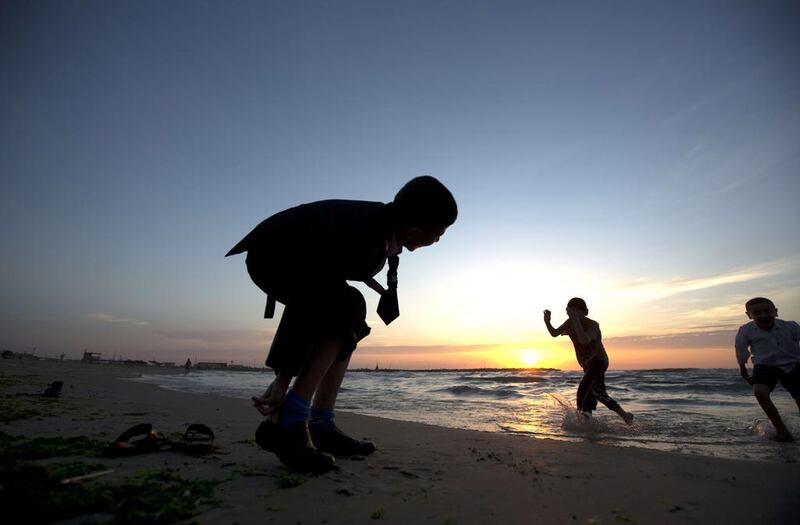 Palestinian children play on the beach in Gaza City, Palestine. Mohammed Abed / AFP