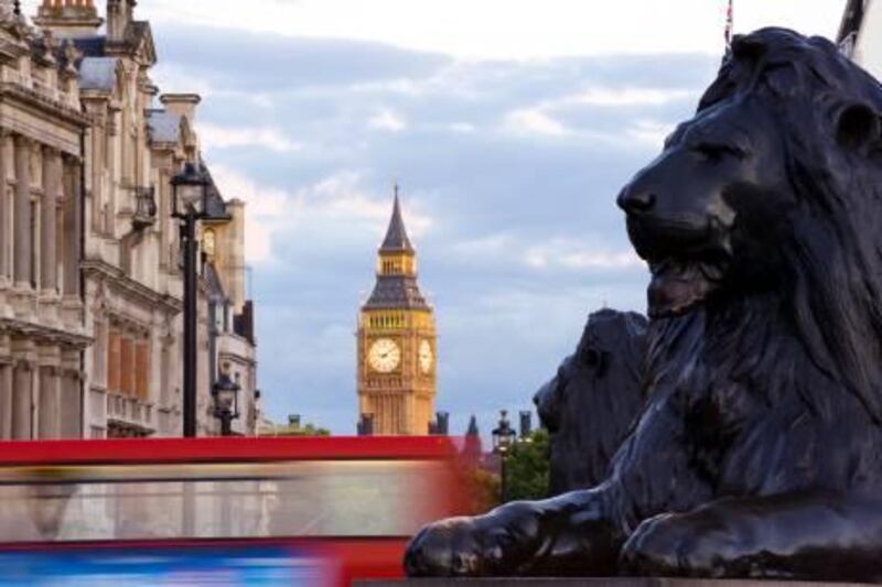 A view of the Clock Tower of Westminster Palace from Trafalgar Square, with the Lion statues in the foreground.