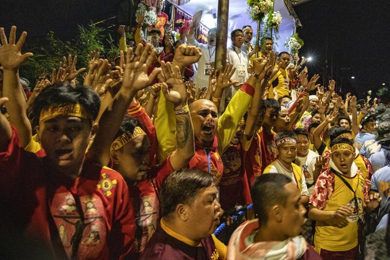 Filipino Catholic devotees raise their hands as they take part in the annual procession of the Black Nazarene. Getty