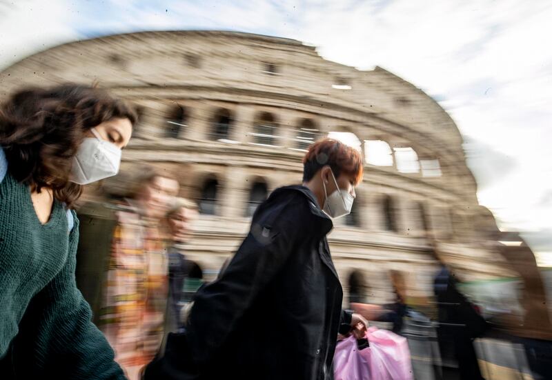 People walk through the centre of Rome, Italy, while wearing face masks. EPA