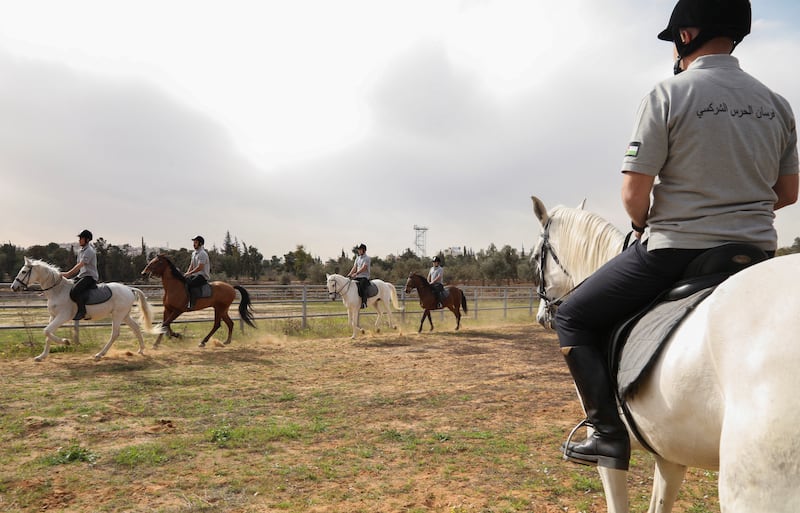 Assistant Commander Hakho looks on as other members train on horses at the royal court in Amman. 'Circassians were all knights and fighters so horses and swords were inevitably present', he says