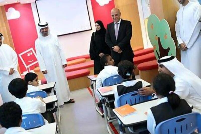 Ahmed Mohammed Al Humairi, left, the secretary general of the Ministry of Presidential Affairs and chairman of the Emirates National Schools, and Mohammed Berro, the chief executive of Al Hilal Bank, visit one of the partner schools in Abu Dhabi where Islamic finance would be taught. Sammy Dallal / The National