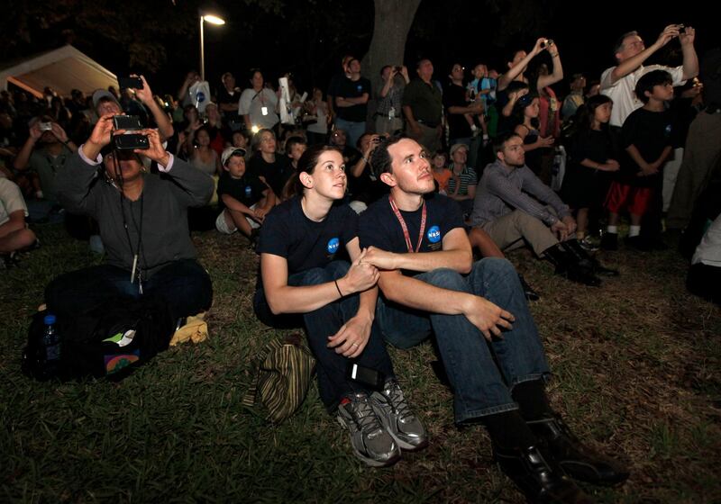 Johnson Space Center employees Jeremy Rea, right, and Shelley Stortz, left, hold hands as they watch space shuttle Atlantis land Thursday, July 21, 2011, in Houston. The landing of Atlantis brings the space shuttle program to an end. (AP Photo/David J. Phillip) *** Local Caption ***  Space Shuttle.JPEG-0e41c.jpg