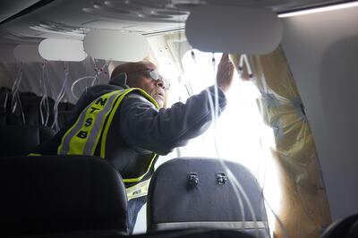 A worker examines the cabin of a Boeing 737-9 Max operated by Alaska Airlines after a fuselage panel blew out forcing pilots to make an emergency landing. EPA
