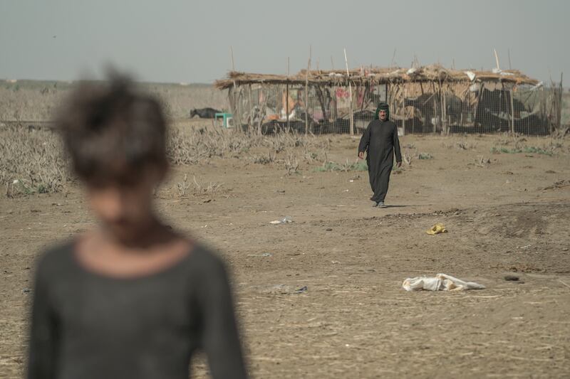 Raheem Noor Dawood and his son at home in the Chabayech Marshes in southern Iraq. Haider Husseini for The National