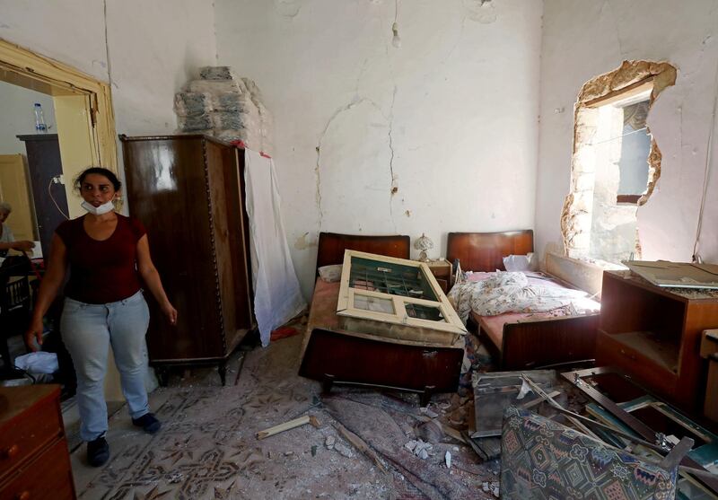 A woman stands inside her damaged home. Reuters