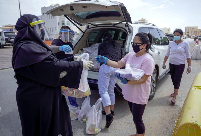 Abu Dhabi, United Arab Emirates, May 1, 2020.   
 Filipino-Emirati, Mona Mohamed Baraguir  (left) donates rice, eggs, cooking oil and other daily essentials to laid off workers at the Khalifa A neighborhood on a Friday morning.
Victor Besa / The National
Section:  NA
Reporter:  Shireena Al Nuwais