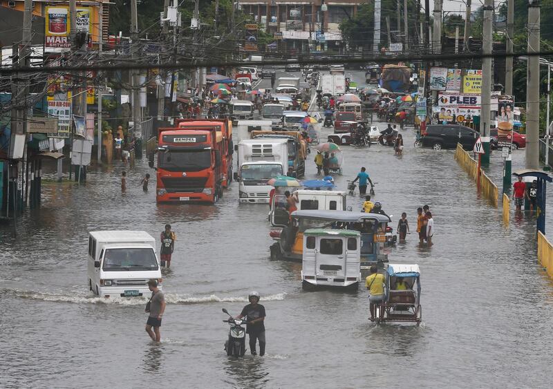 epa06895813 Motorists and citizens travel through a flooded road, a result of rains and coastal tide conditions, in Marilao town of Bulacan Province, north of Manila, Philippines, 18 July 2018. According to state weather bureau, Philippine Atmospheric Geophysical and Astronomical Services Administration (PAGASA) forecast, the southwest monsoon will continue to dump heavy rains over Metro Manila and parts of Luzon amid another tropical depression developing. Streets in the Philippine capital were flooded 17 July after heavy rains soaked the archipelago as Tropical Storm Henry made landfall.  EPA/ROLEX DELA PENA