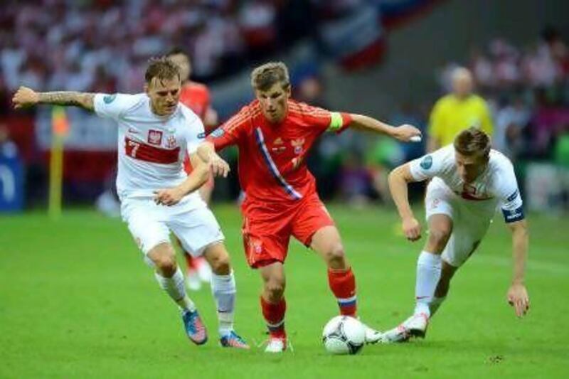 Russia's Andrey Arshavin, centre, gets the better of Poland players in yesterday's match. Shaun Botterill / Getty Images