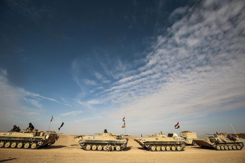 TOPSHOT - Armoured personnel carriers (APCs) of the Iraqi forces and the Hashed al-Shaabi (Popular Mobilisation units) are seen during the advance through Anbar province, 20 kilometres east of the city of Rawah in the western desert bordering Syria, on November 25, 2017, in a bid to flush out remaining Islamic State (IS) group fighters in the al-Jazeera region. / AFP PHOTO / AHMAD AL-RUBAYE