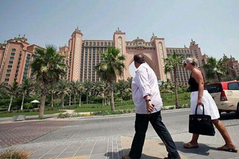 Foreign tourists walk in front of Atlantis in Dubai. Latest figures show the emirate has seen 300,000 more hotel visitors in the first nine months of 2010 than in the same period last year.