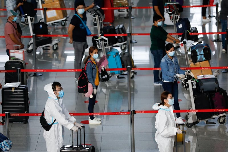 Passengers wearing personal protective equipment queue at the check-in counters of Emirates, at Ninoy Aquino International Airport in Pasay City, Metro Manila, Philippines. Reuters