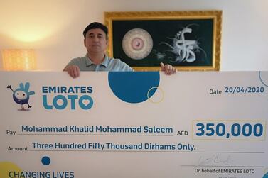 Mohammed Khalid with his cheque for Dh350,000. Courtesy: Emirates Loto