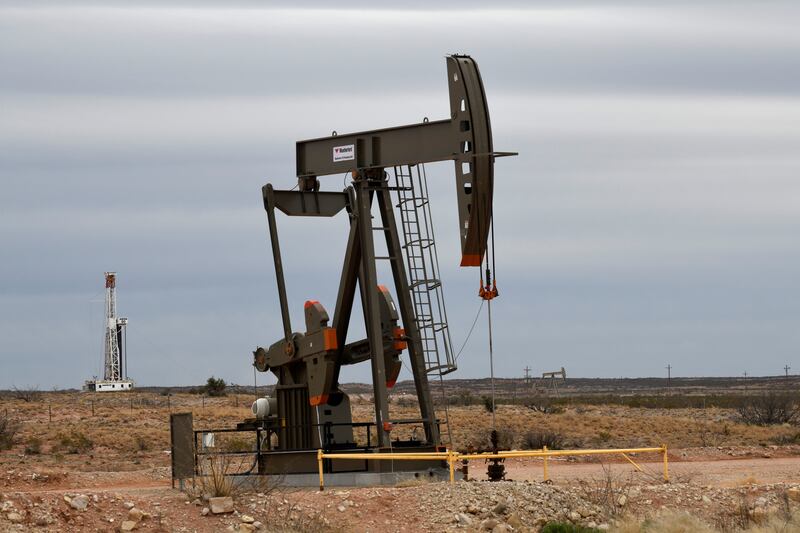 A pump jack and drilling rig in New Mexico. A surprise rise in US inflation stoked concerns of further monetary tightening, weighing on crude futures. Reuters