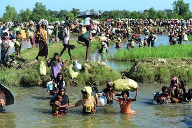 (FILES) In this file photo taken on October 16, 2017, Rohingya refugees walk through a shallow canal after crossing the Naf River as they flee violence in Myanmar to reach Bangladesh in Palongkhali near Ukhia.  - The United States has determined that the violence against the Rohingya minority committed by Myanmar's military amounted to genocide and crimes against humanity, an official told AFP on March 20, 2022.  (Photo by Munir UZ ZAMAN  /  AFP)
