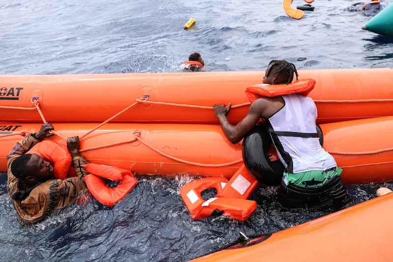 Migrants wait to board the rescue boat.