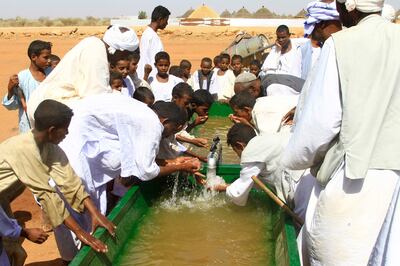 People drink water from a recently dug well in Sudan's eastern state of Gedaref amid continuing fighting between the Sudanese army and the Rapid Support Forces. AFP