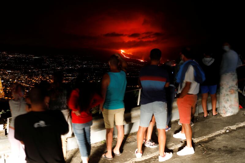 People watch lava flowing during the eruption of a volcano on the Canary Island of La Palma, in Tijarafe, Spain. Photo: Reuters