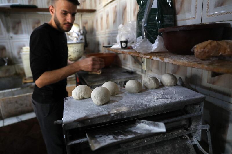 A staff member prepares the dough to make garnished flatbread at the bakery in Beirut. AFP