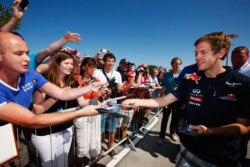 ABU DHABI, UNITED ARAB EMIRATES - NOVEMBER 11:  Sebastian Vettel of Germany and Red Bull Racing signs autographs for fans before practice for the Abu Dhabi Formula One Grand Prix at the Yas Marina Circuit on November 11, 2011 in Abu Dhabi, United Arab Emirates.  (Photo by Mark Thompson/Getty Images) *** Local Caption ***  132202072.jpg