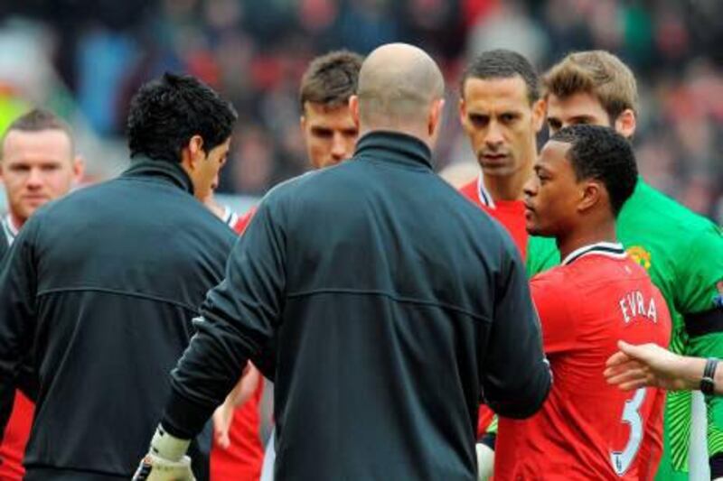 Luis Suarez, left, refused to shake the hand of Patrice Evra, left.