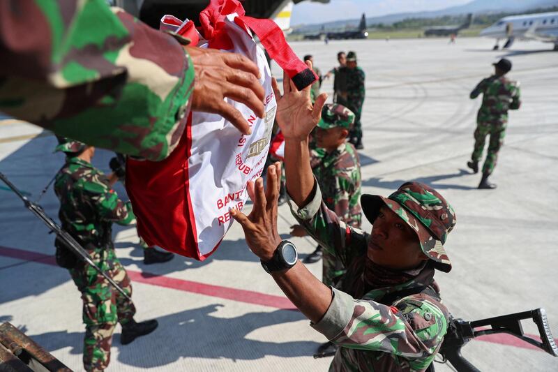 Soldiers unload relief supplies from a military aircraft in Palu. Reuters