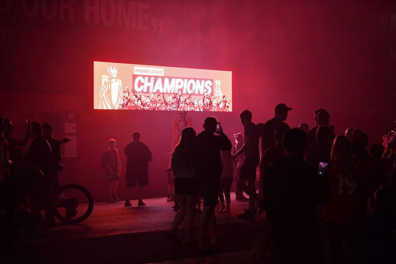 Fans celebrate Liverpool winning the Premier League title outside Anfield stadium on Thursday. AFP