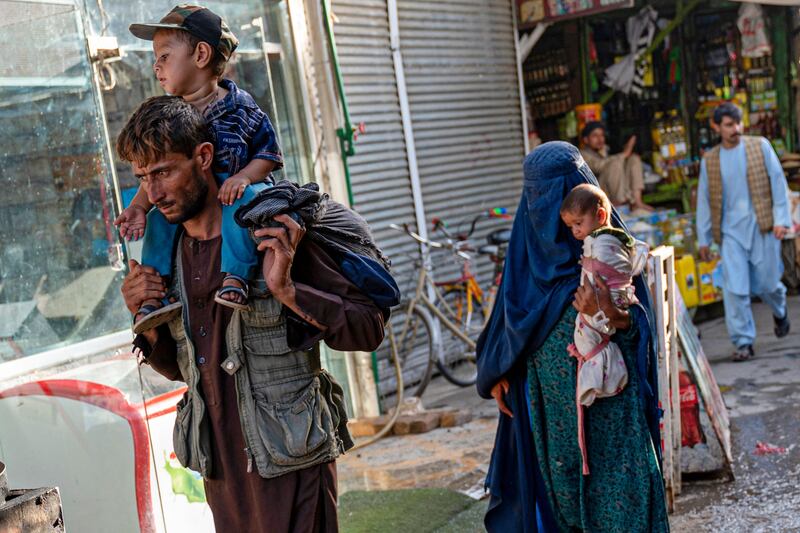 An Afghan family walk past a market near the Pul-e Khishti Mosque in Kabul. AFP