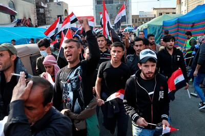 Hundreds of people march inside Tahrir Square carrying national flags and chanting religious slogans in Baghdad, Iraq, Thursday, Dec. 5, 2019. Anti-government protesters at least 15 people have suffered stab wounds in Baghdad's Tahrir Square, the epicenter of their movement, after political parties and Iran-backed militia groups briefly joined them, raising fears of infiltration by authorities. (AP Photo/Hadi Mizban)