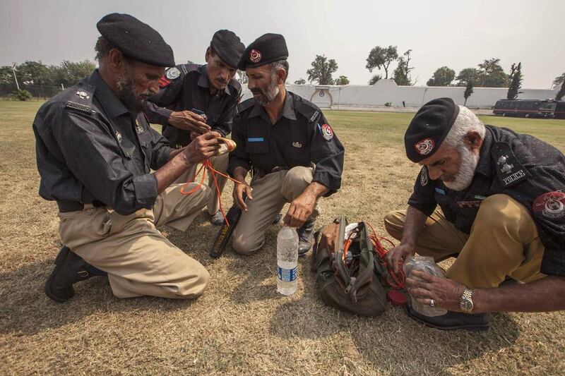 Technicians from Pakistan’s top bomb disposal unit prepare an improvised detonator, by fixing a cord into a plastic water bottle, to demonstrate how to destroy bombs at the unit’s headquarters in Peshawar. Zohra Bensemra / Reuters