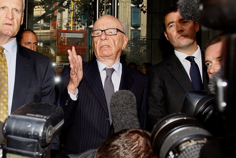 Rupert Murdoch, centre, attempts to speak to the media after he held a meeting with the parents and sister of murdered school girl Milly Dowler in London, Friday, July 15, 2011. The lawyer for Milly Dowler's family says Rupert Murdoch has issued a full and sincere apology to the murdered schoolgirl's family for the actions of journalists at his newspaper. Mark Lewis told reporters that the media baron called the private meeting and apologized "many times," telling the Dowlers the events that transpired at the News of the World tabloid were not in keeping with the standards set out when his own father entered the media industry. (AP Photo/Kirsty Wigglesworth) *** Local Caption ***  APTOPIX Britain Phone Hacking.JPEG-0d98b.jpg