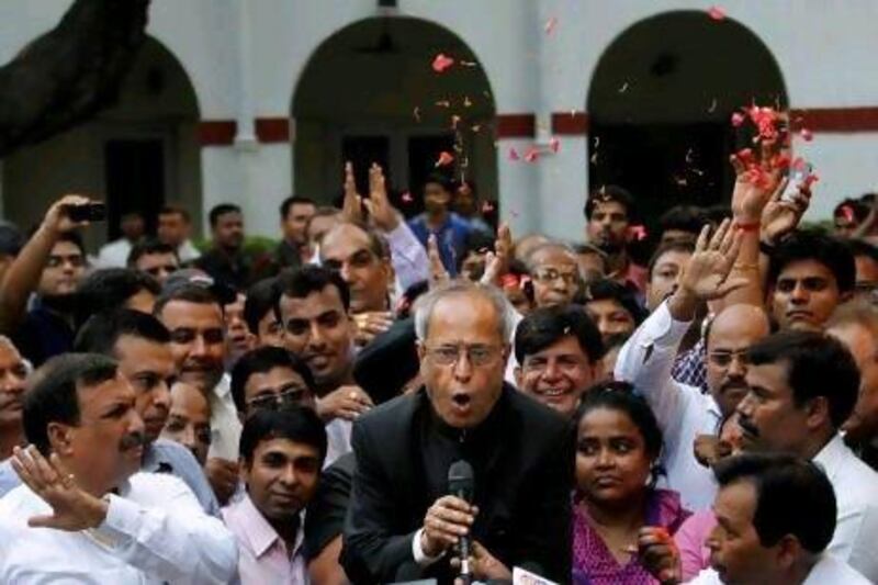 Relatives throw flower petals as India's president elect Pranab Mukherjee addresses the media outside his New Delhi residence after his victory.