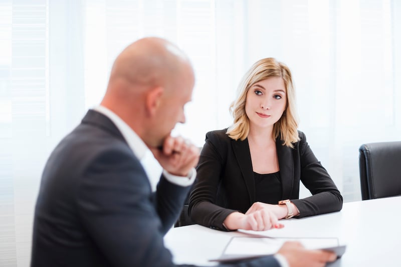 Businessman and businesswoman talking in office. Getty Images