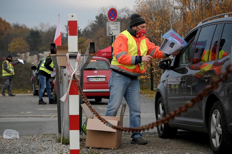 A worker hands out flyers in a parking lot near the Amazon logistic center in Rheinberg. EPA