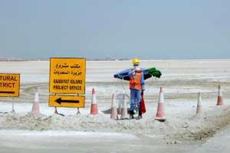 ABU DHABI, UNITED ARAB EMIRATES - June 24, 2009: A construction worker and signs on Saadiyat Island in Abu Dhabi.  ( Ryan Carter / The National ) *** Local Caption ***  RC007-StockTouristClub.JPG