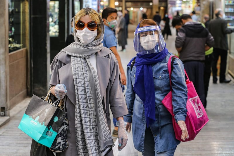 Shoppers clad in protective gear, including face masks and shields and latex gloves, due to the coronavirus pandemic, walk through the Tajrish Bazaar in Iran's capital Tehran on April 25, 2020. AFP