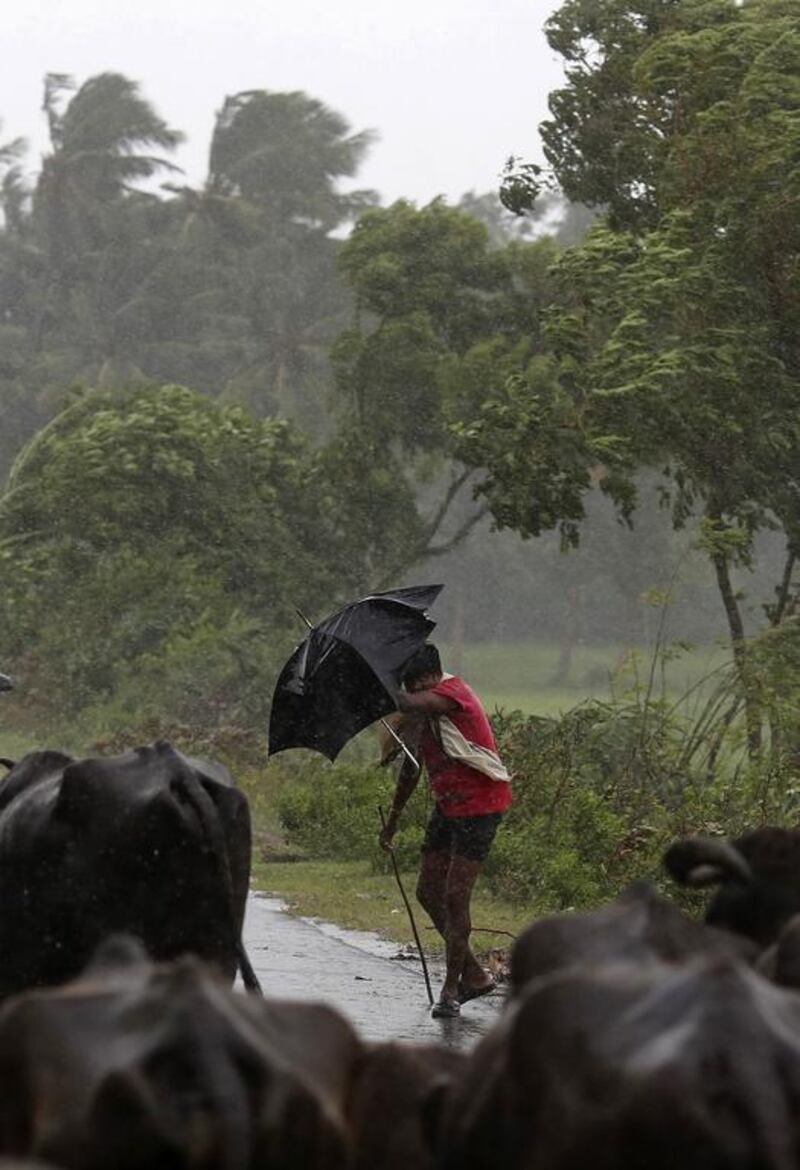 A boy tries to cover himself with an umbrella during heavy rain brought by Cyclone Phailin in Ichapuram town in Srikakulam district in the southern Indian state of Andhra Pradesh. Reuters/Adnan Abidi