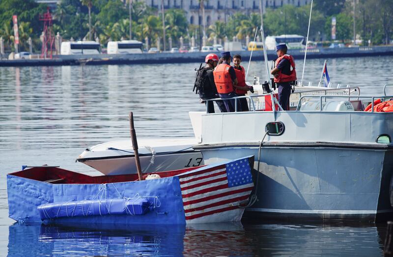 Cuban coastguard members stand near a boat that was used by people trying to migrate to the US. Reuters
