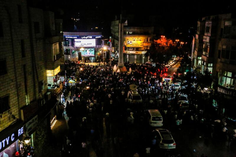 Palestinians watch Palestinian president Mahmoud Abbas on a large screen in the West Bank city of Ramallah. AFP