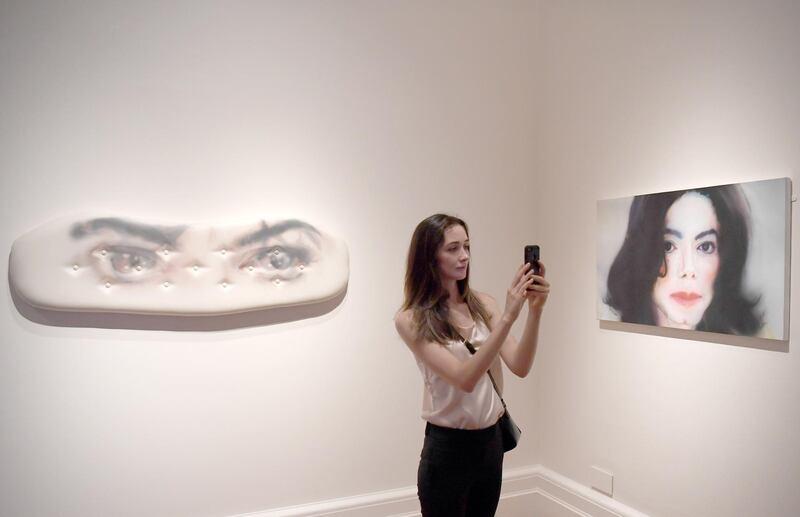 A woman takes photographs during a press preview of the exhibition "Michael Jackson: On the Wall" at the National Portrait Gallery in London, Britain, on June 27, 2018. Neil Hall / EPA