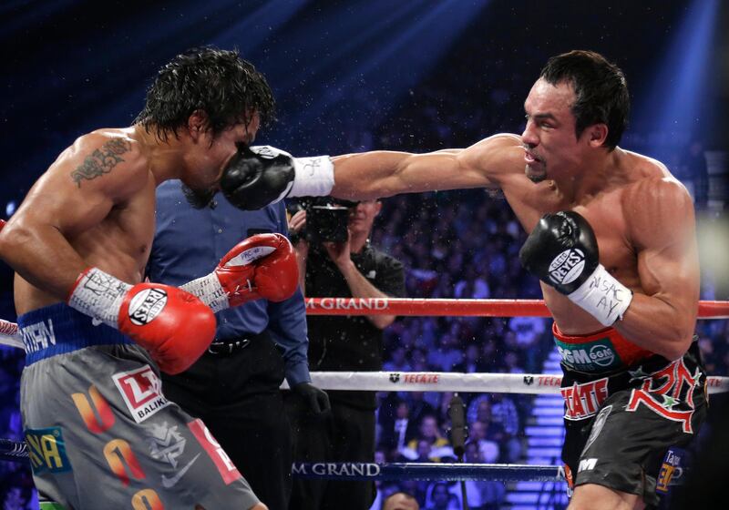 Juan Manuel Marquez, from Mexico, right, lands a right to the head of Manny Pacquiao, from the Philippines, during their WBO world welterweight  fight Saturday, Dec. 8, 2012, in Las Vegas. Marquez won by a knockout. (AP Photo/Julie Jacobson) *** Local Caption ***  Pacquiao Marquez Boxing.JPEG-0abd0.jpg